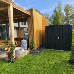 Zwarte container naast een vakantie huisje