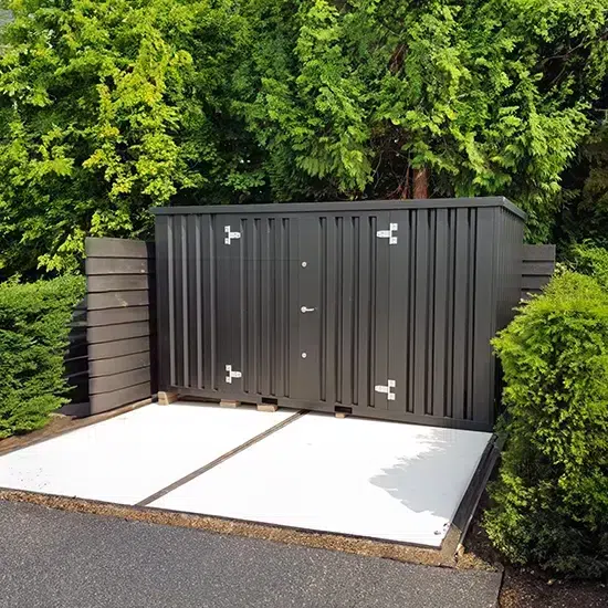 Kleine gekleurde container geplaatst in de tuin,