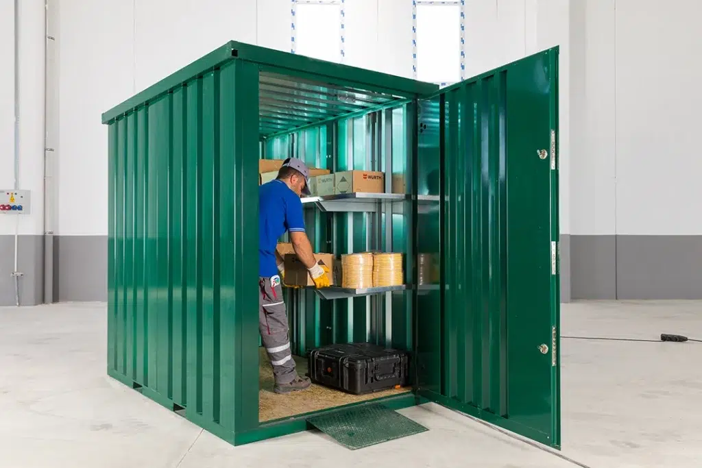 Groene tuincontainer met een open deur in een loods