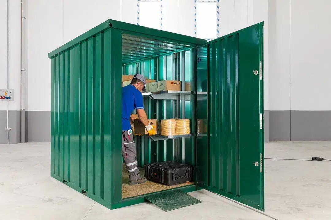 Groene tuincontainer met een open deur in een loods