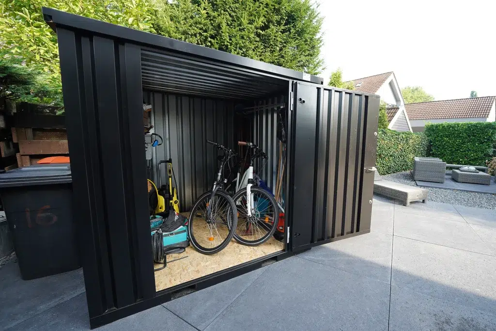 Zwarte container met een open deur en fietsen opgeslagen