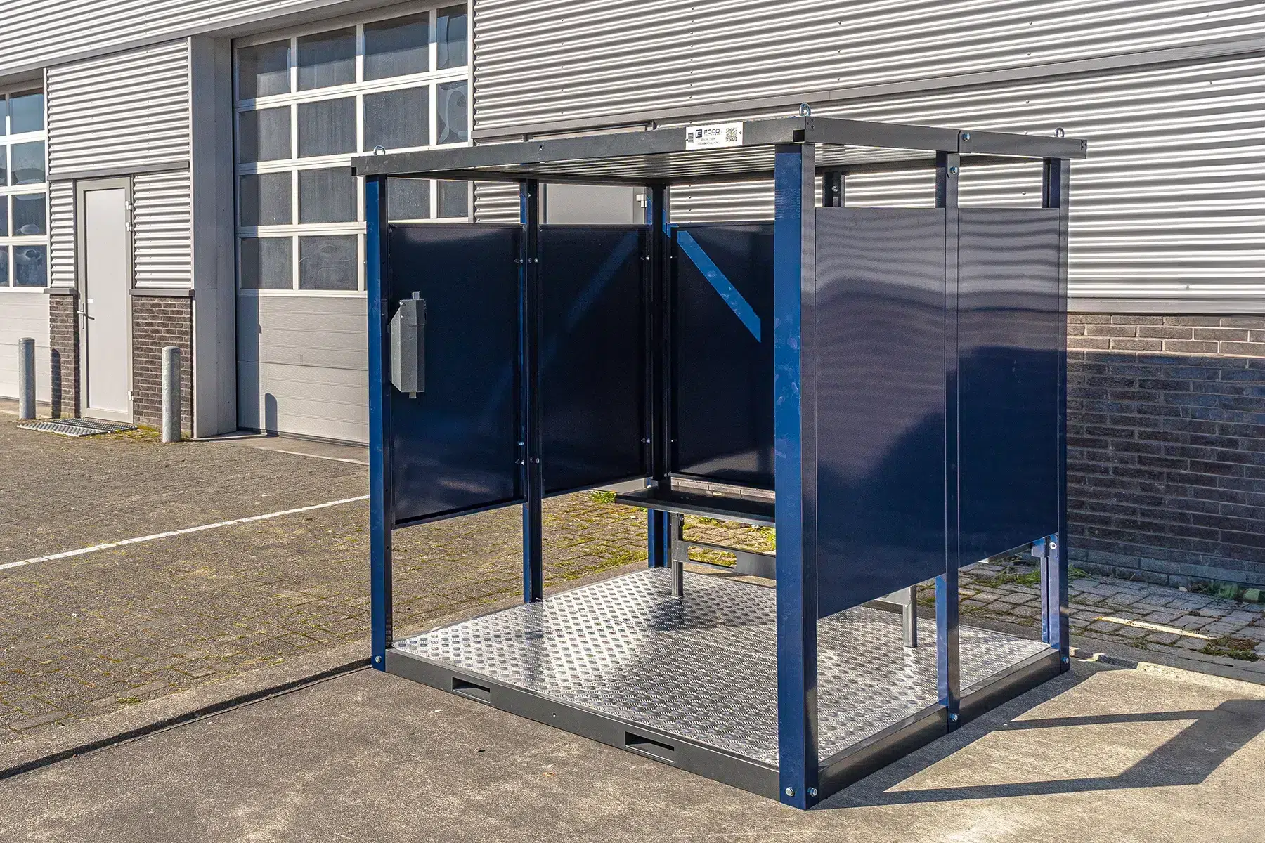 Rookcontainer naast een loods