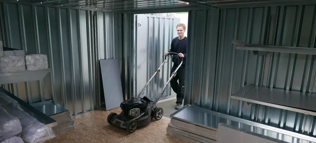 iemand die een grasmaaiier in een container zet