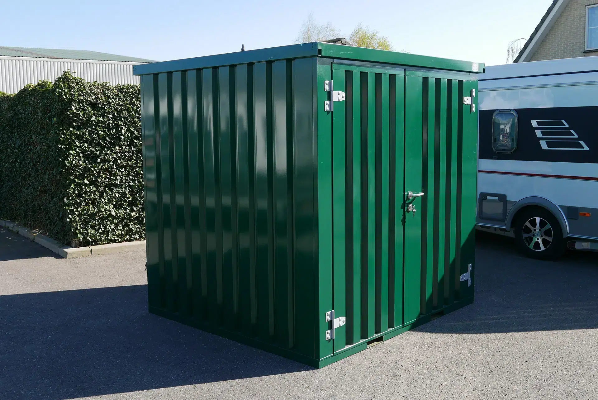 Groene container met twee dichte deuren op een parkeerplaats