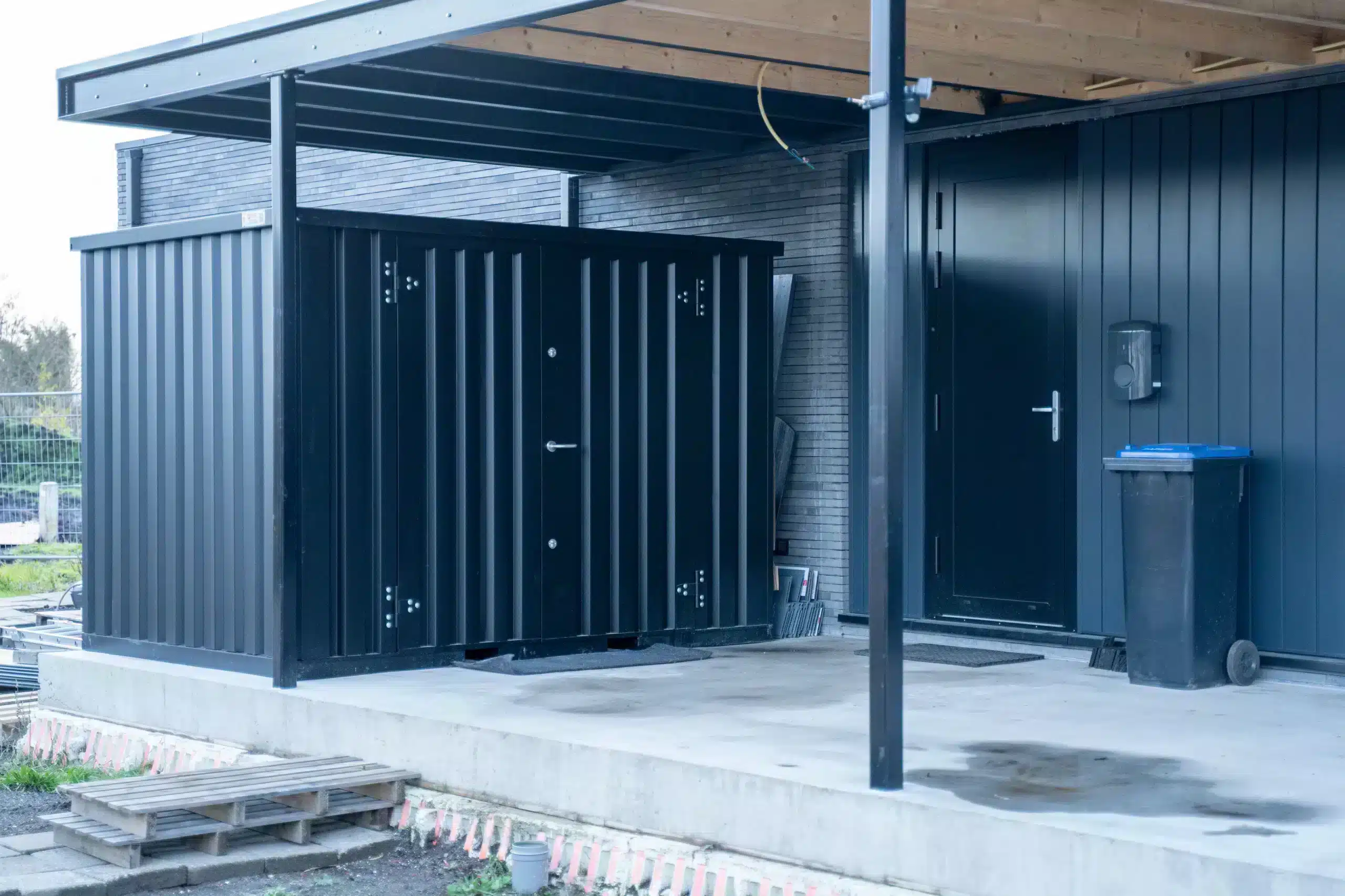 zwarte opslagcontainer bij huis