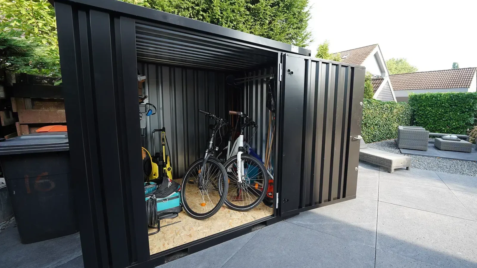 Foto van een zwarte demontabele container met fietsen gestald